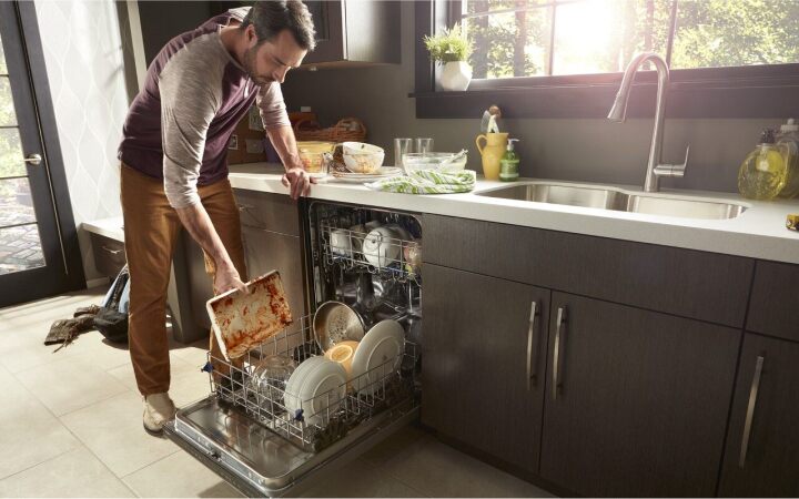 一名男子在现代厨房里装洗碗机