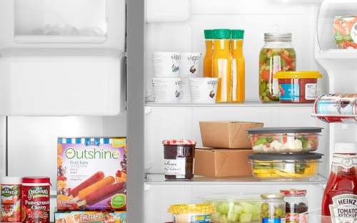 各种食品和饮料储存在一个并排的冰箱