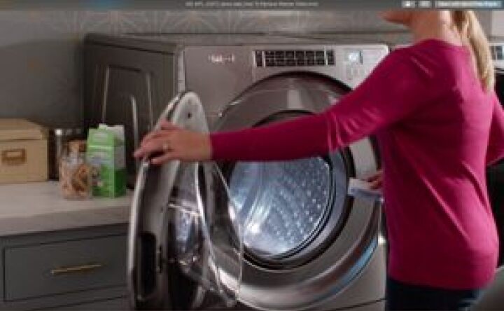 用清洁布擦拭洗衣机开口的妇女