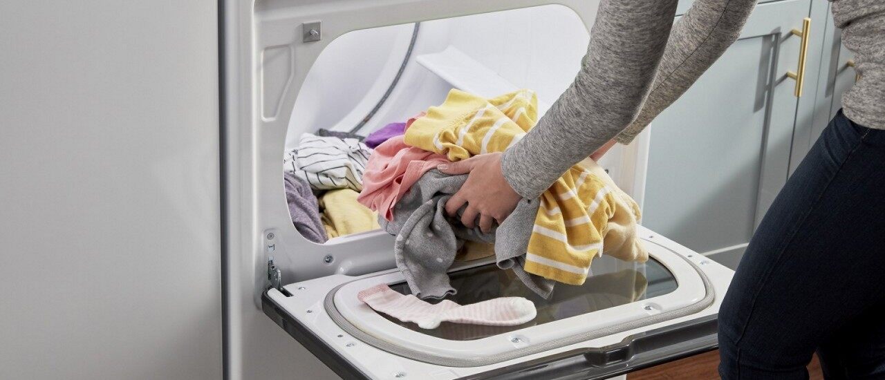 一个女人把要洗的衣服放进干净的烘干机
