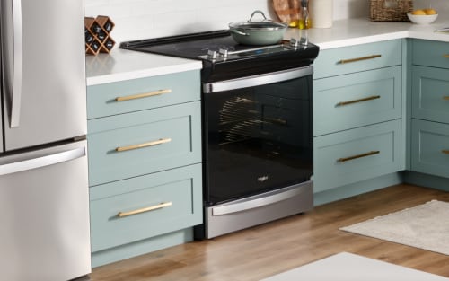 惠而浦®电动炉灶在厨房与蓝绿色橱柜