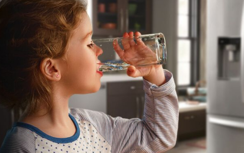 一个小女孩用杯子喝水