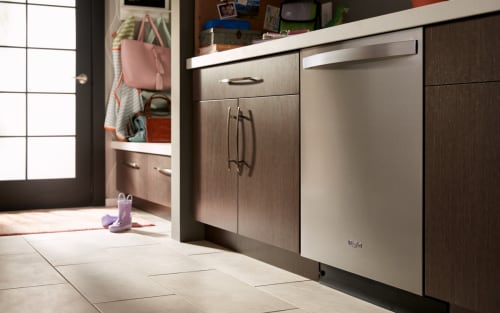 一个惠而浦®顶部控制洗碗机周围的棕色橱柜