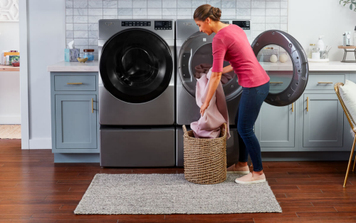 一个女人准备干燥的衣物使用惠而浦®洗衣机和烘干机对负荷