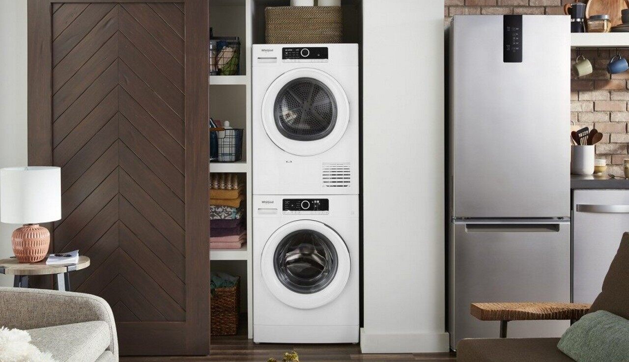 在一间现代化阁楼的壁橱里，有一堆紧凑的洗衣机和烘干机