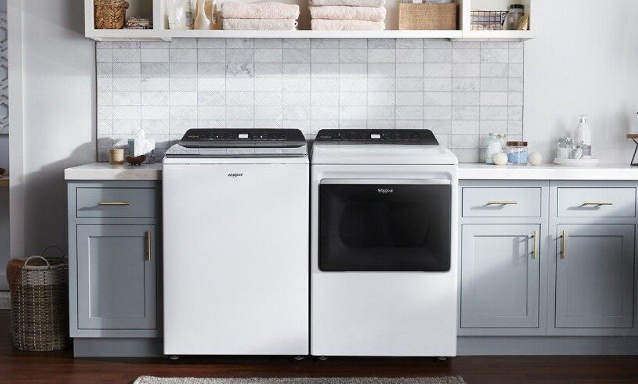 现代洗衣房里的白色顶装洗衣机和烘干机